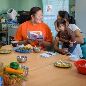 World Vision staff with mother and child