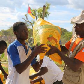 A World Vision employees gives food to people during a disaster