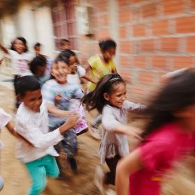 A group of children run in Colombia
