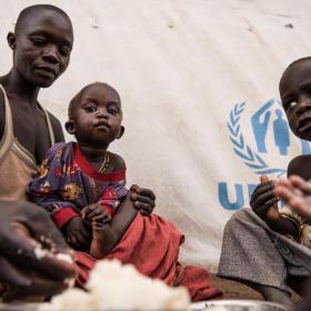Amandru and her children eat the first proper meal they have eaten in a long time. World Vision and World Food Programme (WFP) serve hot meals to South Sudanese refugees in Uganda.