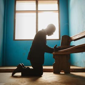 A Pastor on his knees praying