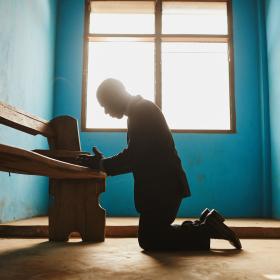 Man kneeling to pray in Ghana