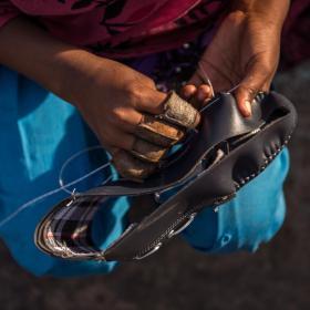 Kanya (12) stitches shoes at her home in Agra, India