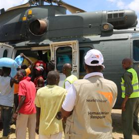 World Vision employees and locals getting food from a helicopter