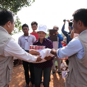 World Vision Cambodia staff members distributing emergency resources to community member in flood affected Cambodia.
