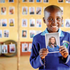 Nine-year-old Mary holds a picture of her sponsor that she chose.