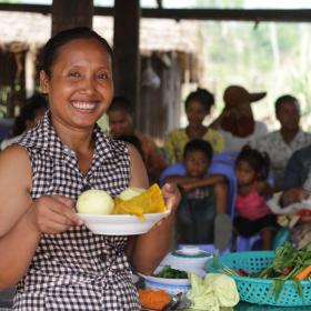 Khmer woman hold bowl of cut vegetables ready to do nutritious food cooking demonstration, Cambodia