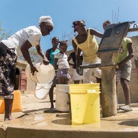 A group of people at a water well in Haiti