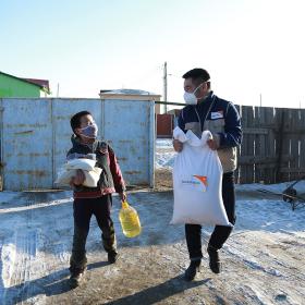 World Vision staff in Mongolia walks with child
