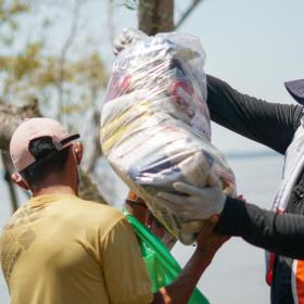 WVI staff hands bag of food to villager