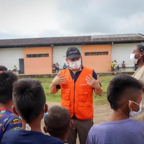 World Vision staff speaks to children