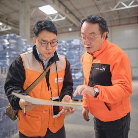 two WVI staff stand in a warehouse talking