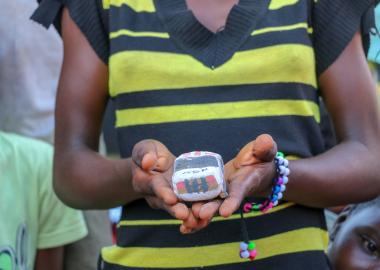 A girl holds the model car she's made at the Child Friendly Space Children at Child Friendly Spaces learn local handicrafts as a form of art therapy