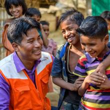 A World Vision employee smiles with some children in Bangladesh