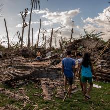 A family in the Philippines surveys the devastation of Typhoon Haiyan