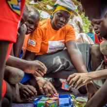 World Vision staff playing a game with children